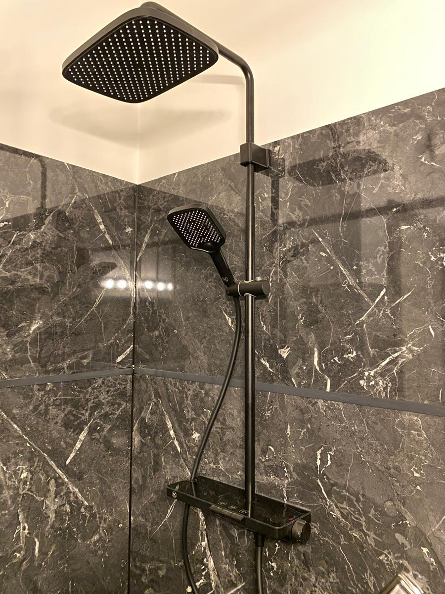 Colonne de douche noire WasserKraft installée sur un décor marbre gris